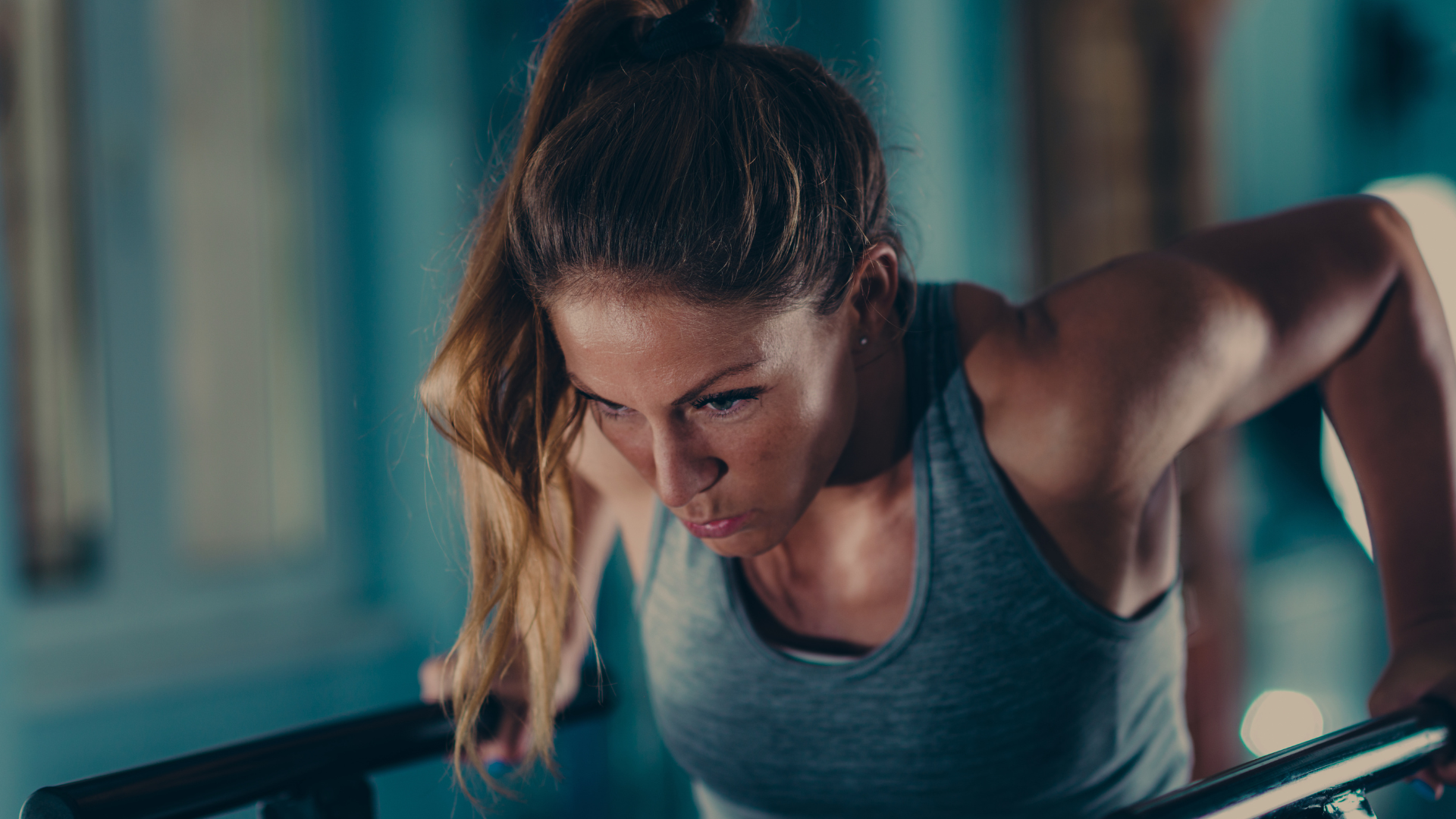 Female athlete performing push-ups in a gym with intense focus